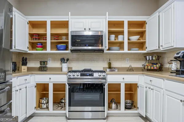 a kitchen with stainless steel appliances granite countertop a stove and cabinets