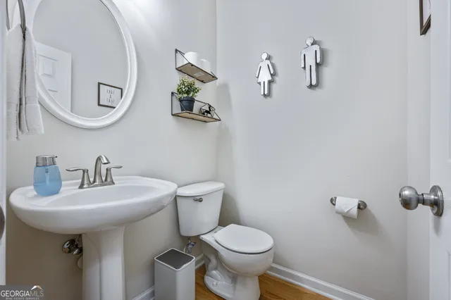 a bathroom with a sink toilet and a mirror