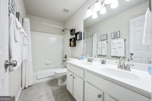 a bathroom with a double vanity sink mirror and toilet