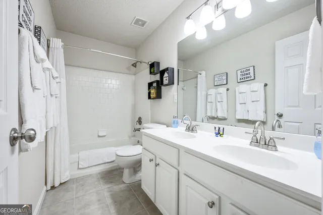 a bathroom with a double vanity sink mirror and toilet