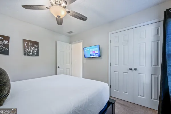 a bedroom with a large bed and a chandelier