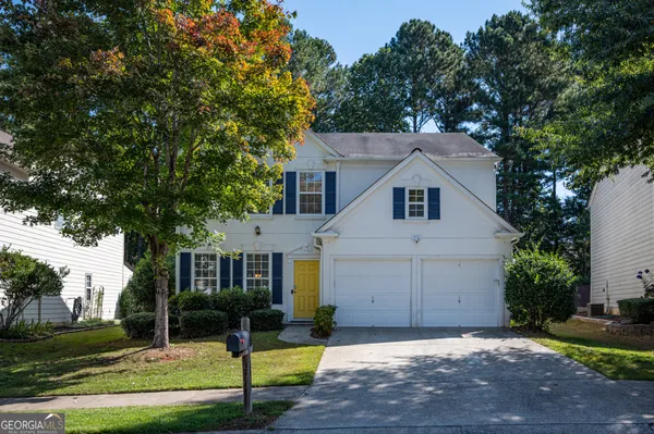 a view of a white house with a yard and large tree