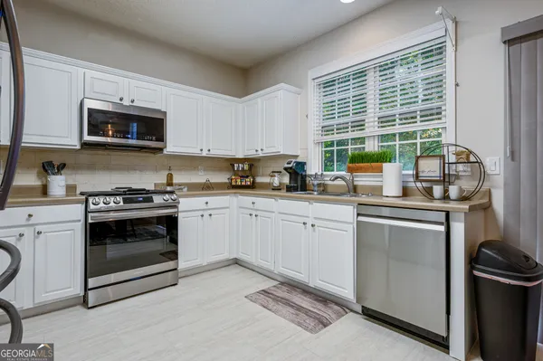 a kitchen with a stove a sink and a microwave