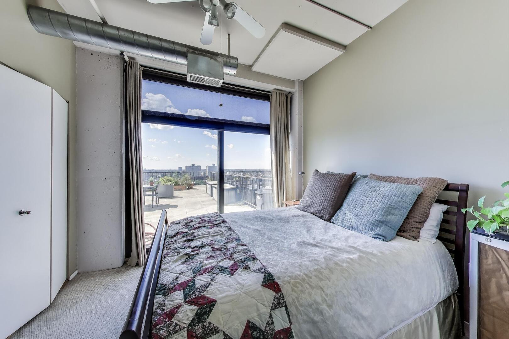 1530 South State Street, Unit 12J Chicago, IL 60605 - Photo 12 of 28 a bedroom with a large bed and a large window