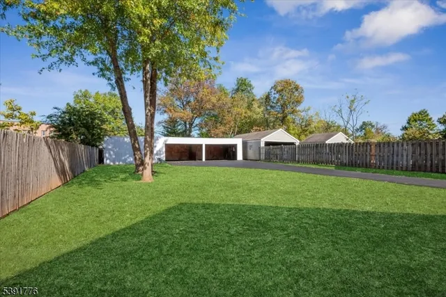 a view of a house with backyard and a tree