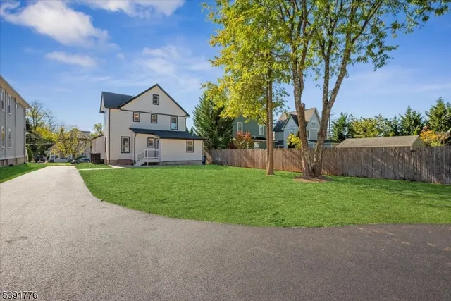 a front view of a house with a yard and tree