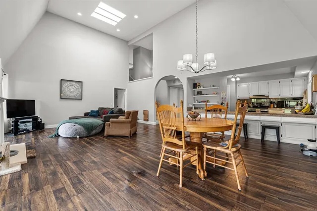 a living room with furniture kitchen view and a wooden floor