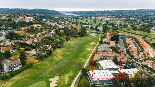an aerial view of residential houses with outdoor space and trees