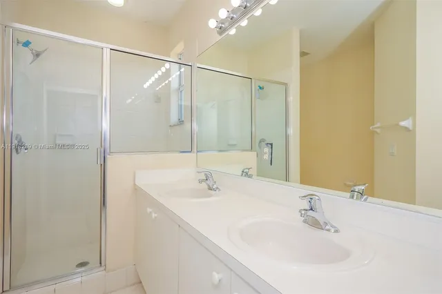 a bathroom with a sink a shower and a mirror