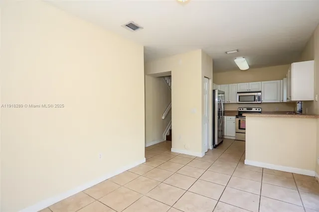 a view of a kitchen with white cabinets