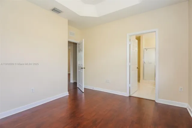 an empty room with wooden floor and closet