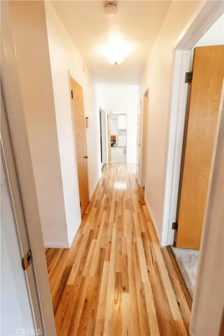 a view of a hallway with wooden floor and staircase