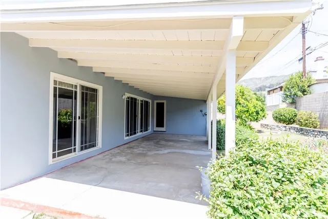 a view of a house with a yard and potted plants