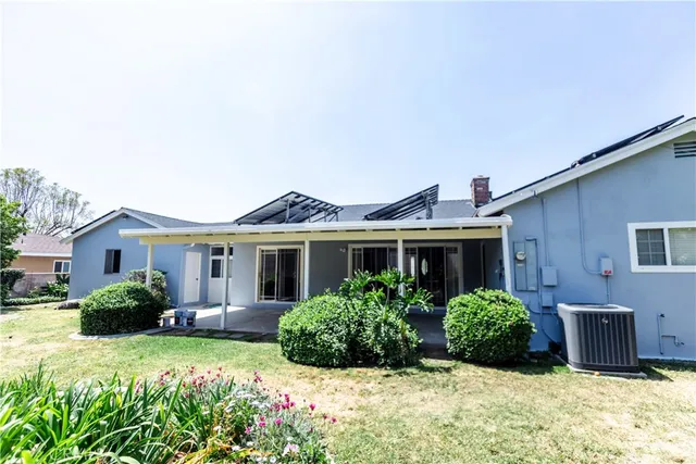 a view of a house with backyard and sitting area