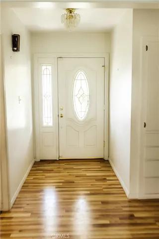 a view of empty room with window and wooden floor