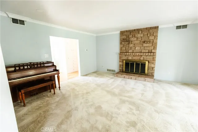 a view of an empty room with exposed radiator and fireplace