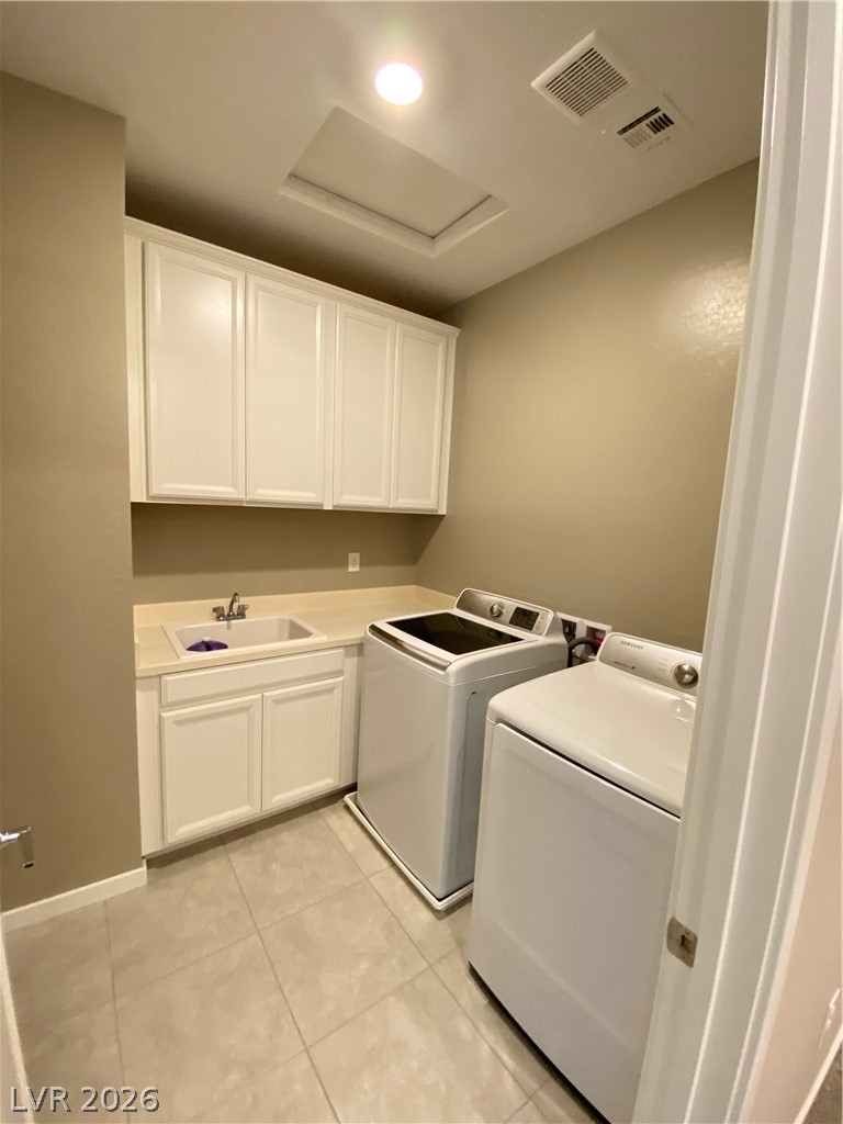 695 Daylight Ridge Court Henderson, NV 89052 - Photo 18 of 27 Laundry room with cabinet space, light tile patterned flooring, and washing machine and dryer