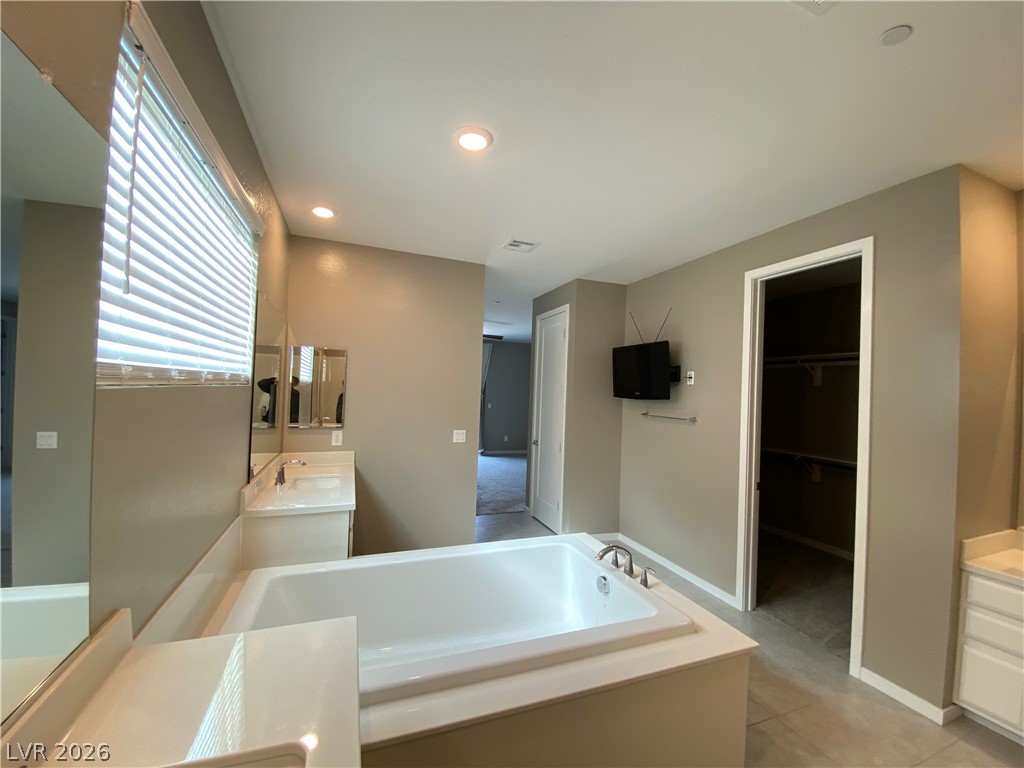 695 Daylight Ridge Court Henderson, NV 89052 - Photo 21 of 27 Bathroom with two vanities, a bath, a walk in closet, recessed lighting, and light tile patterned flooring