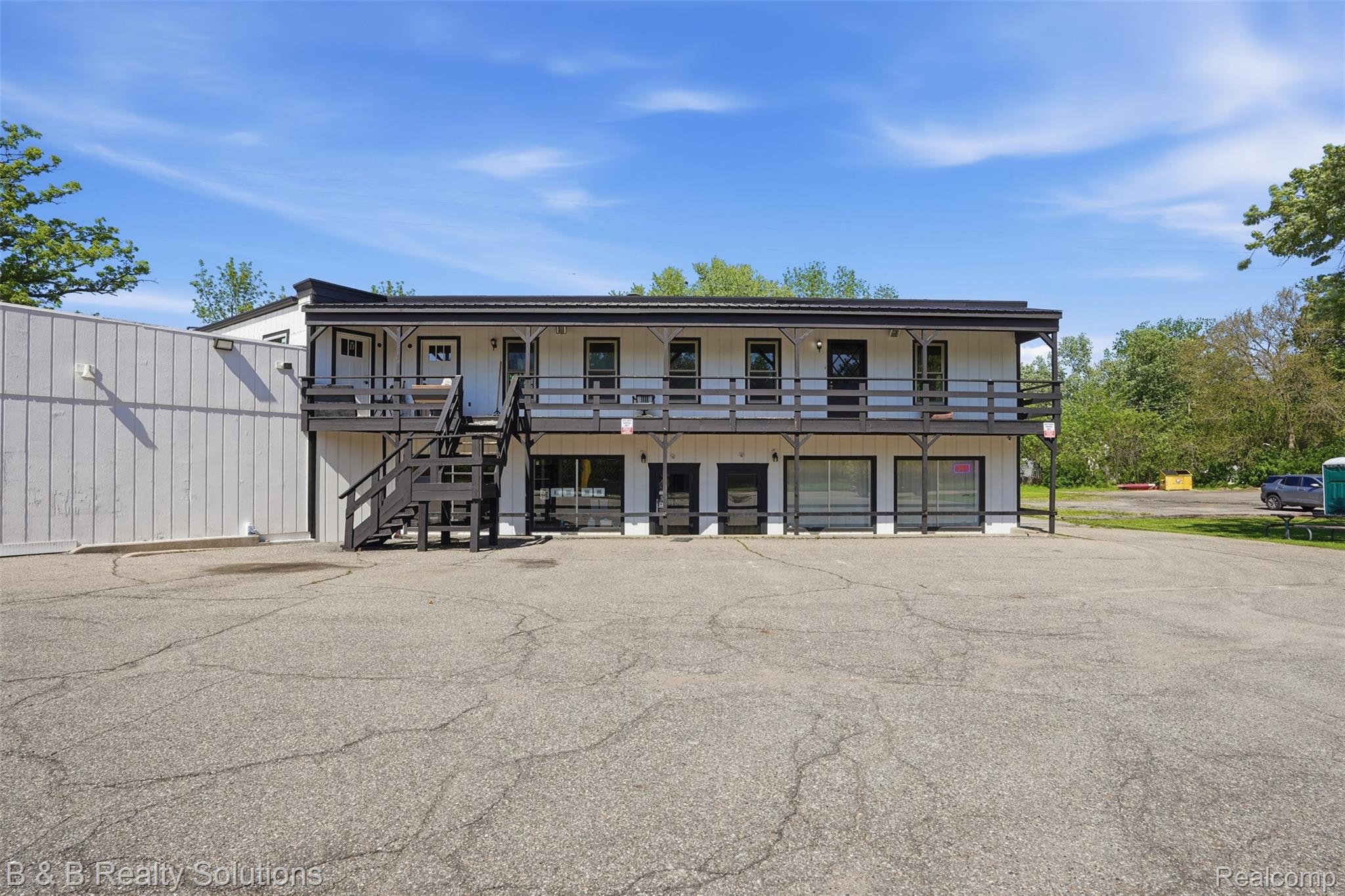 780 North Van Dyke Road, Unit APARTMENT #1 Almont, MI 48003 - Photo 1 of 28 Two-story commercial building featuring multiple ground-floor retail storefronts and second-story units with individual entrances