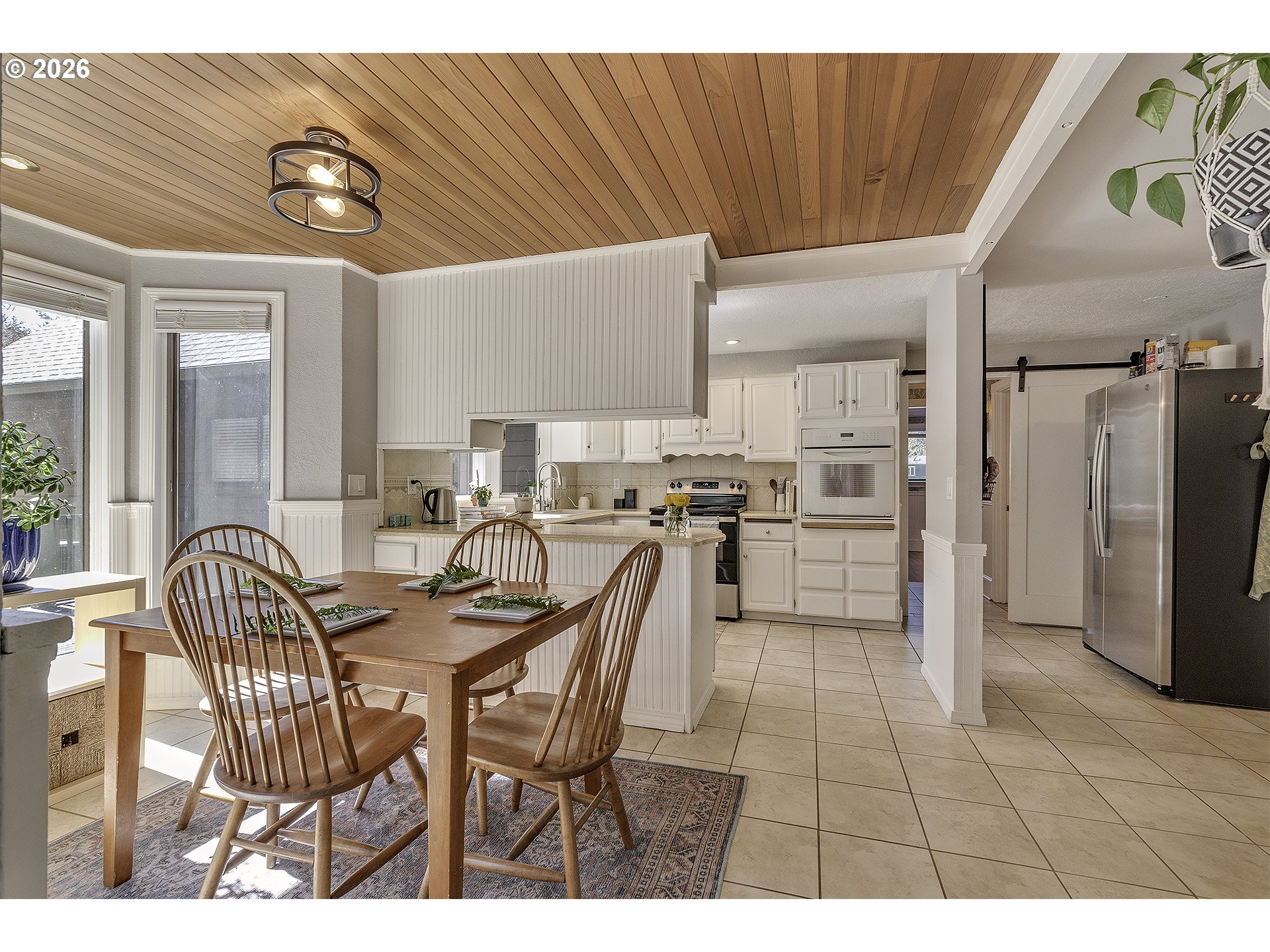 34049 West Campbell Loop Seaside, OR 97138 - Photo 15 of 48 a open kitchen with stainless steel appliances kitchen island granite countertop a refrigerator a stove a sink dishwasher with a dining table and chairs