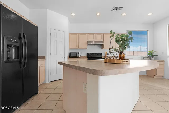 a kitchen with a dining table chairs refrigerator and a sink