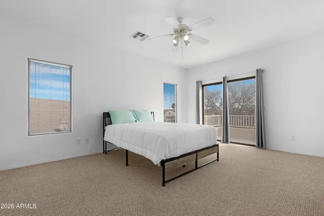 a view of an empty room with chandelier fan