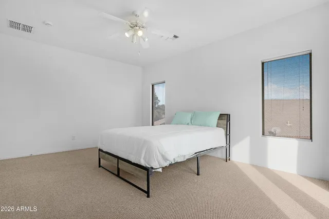 a bed sitting in a bedroom next to a window