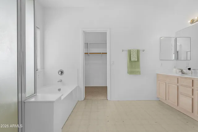 a bathroom with a tub sink and mirror