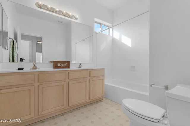 a bathroom with a sink a toilet a mirror and shower