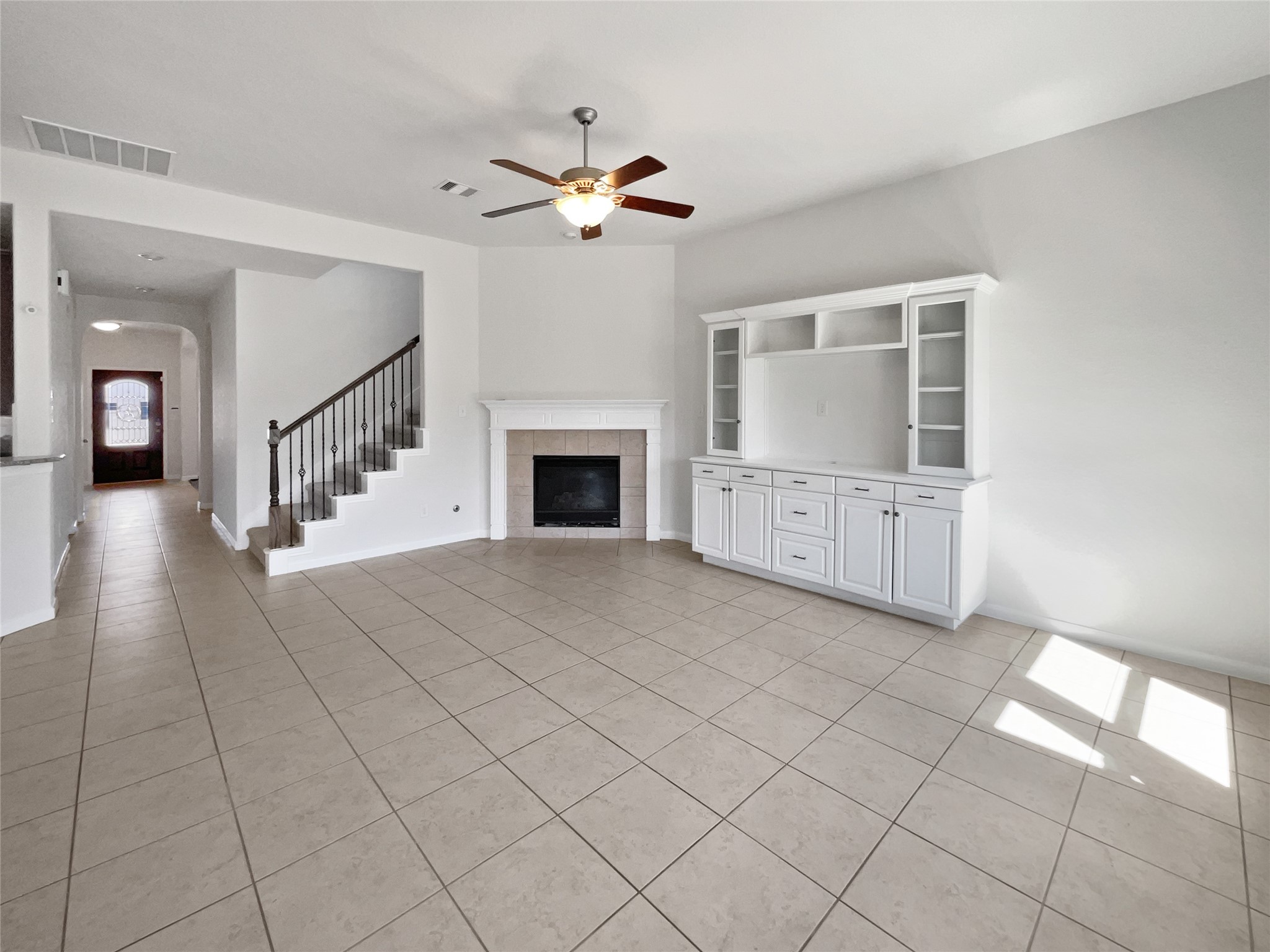 7323 Collins Manor Drive Spring, TX 77389 - Photo 3 of 22 a view of an empty room with a fireplace and a chandelier fan