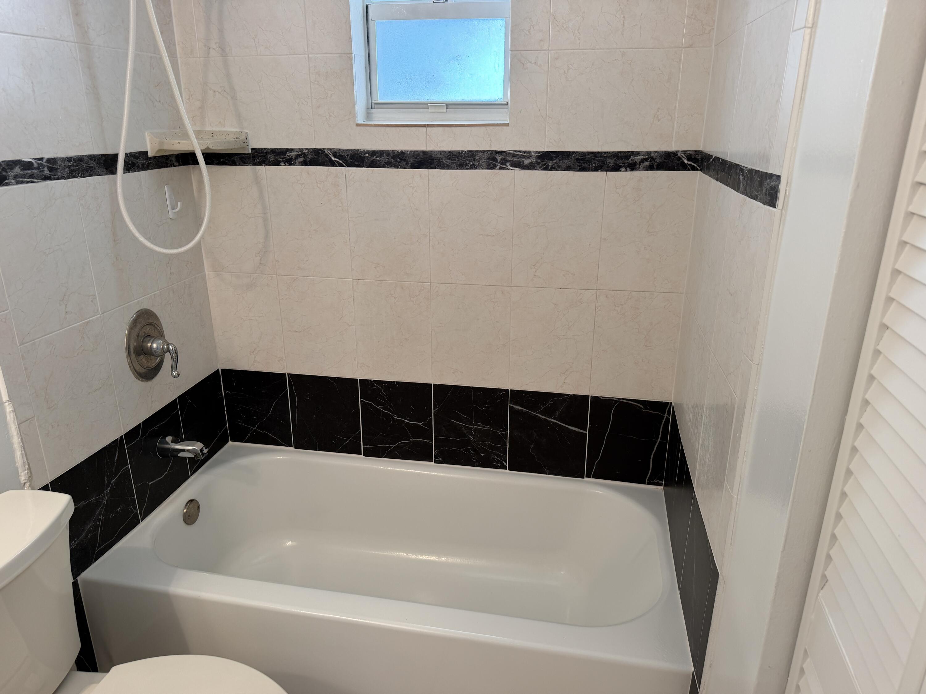 506 Davis Road, Unit 70 Palm Springs, FL 33461 - Photo 24 of 25 a bathroom with a bathtub