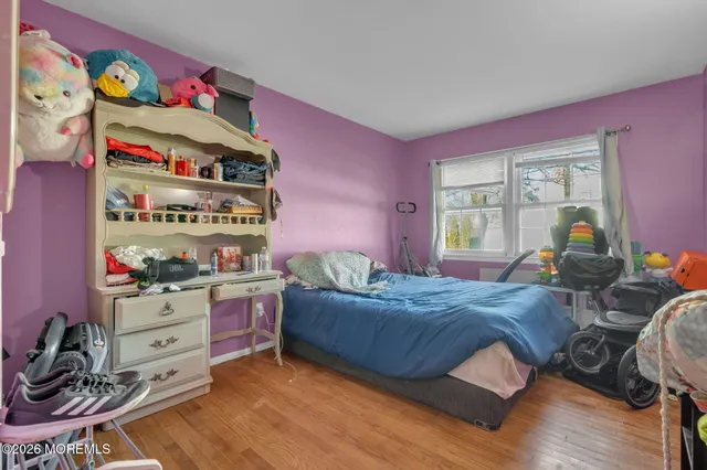 a bedroom with a bed and a wooden floor