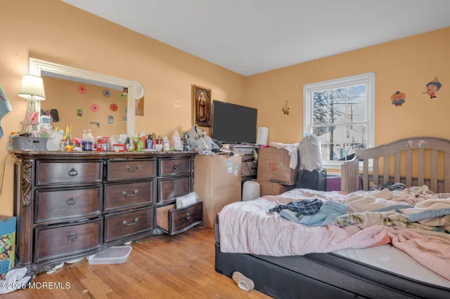 a bedroom with a bed and wooden floor