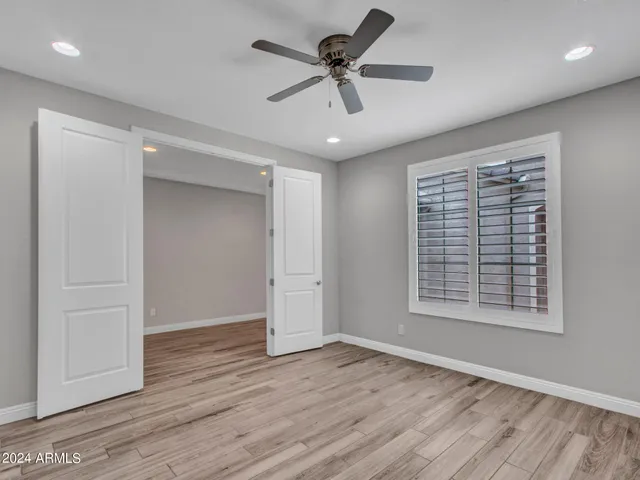 an empty room with a window and a fan