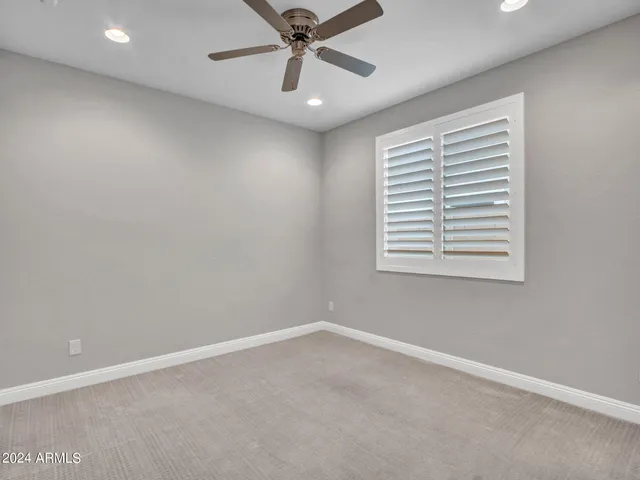 an empty room with a fan and a ceiling fan