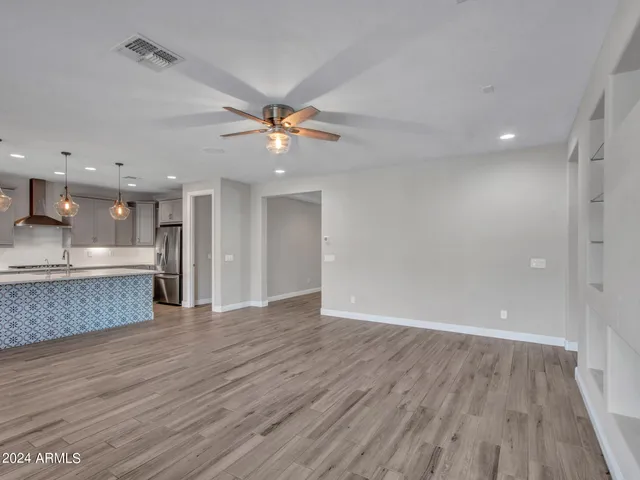 a kitchen with kitchen island granite countertop a sink a counter space appliances and cabinets