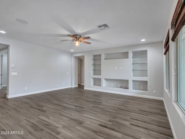 a kitchen with kitchen island granite countertop a stove a sink and a wooden floors