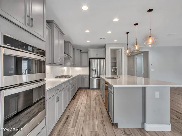 a kitchen with kitchen island granite countertop a sink stove and wooden cabinets