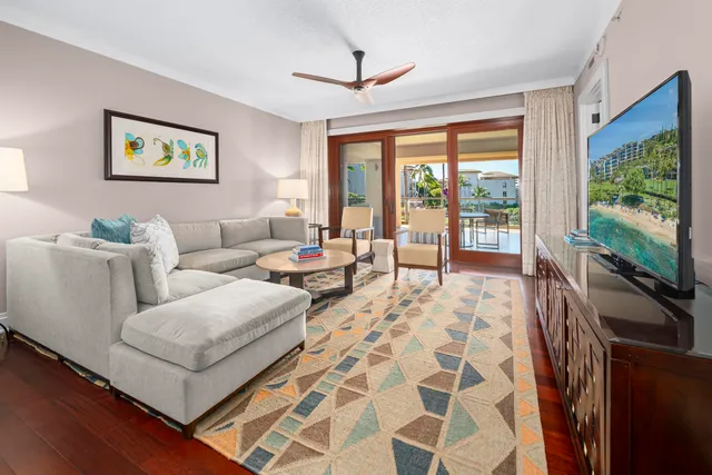 a living room with furniture a flat screen tv and a floor to ceiling window