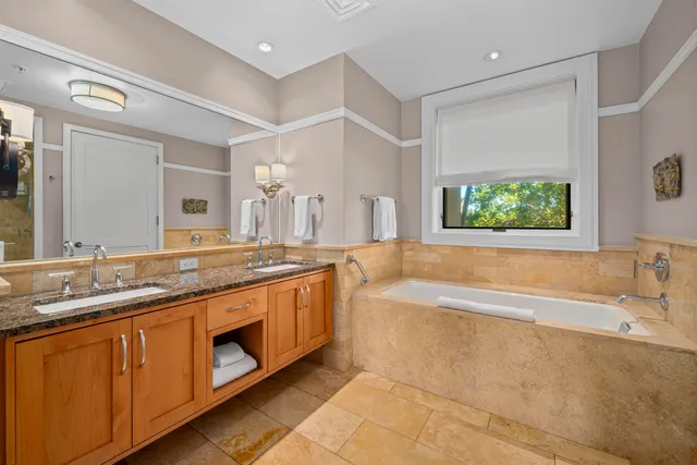 a spacious bathroom with a granite countertop tub sink and mirror