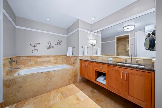 a spacious bathroom with a tub sink and mirror