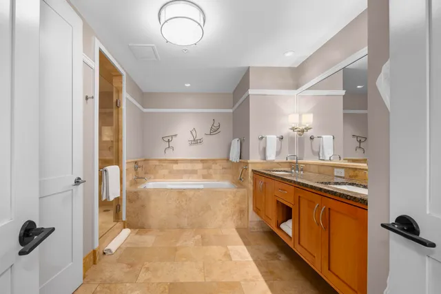 a spacious bathroom with a granite countertop sink a mirror and a bathtub