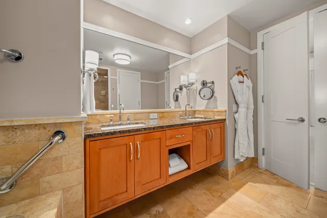 a spacious bathroom with a granite countertop sink and a mirror