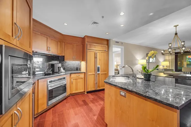 a kitchen with stainless steel appliances granite countertop a sink stove and refrigerator
