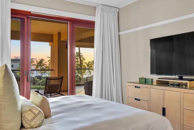 a bedroom with a bed and a flat tv screen next to a window