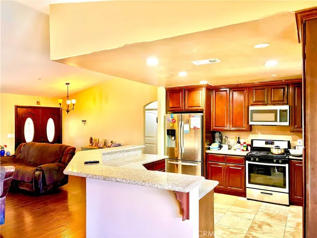 a kitchen with stainless steel appliances kitchen island granite countertop a sink and cabinets