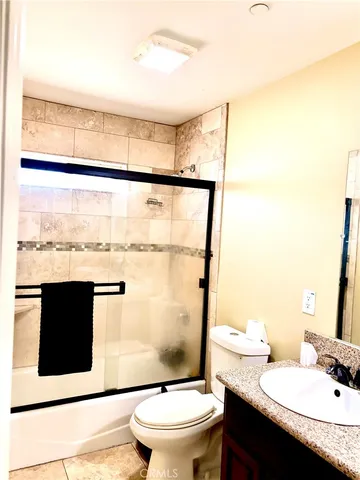 a bathroom with a granite countertop sink mirror vanity and toilet