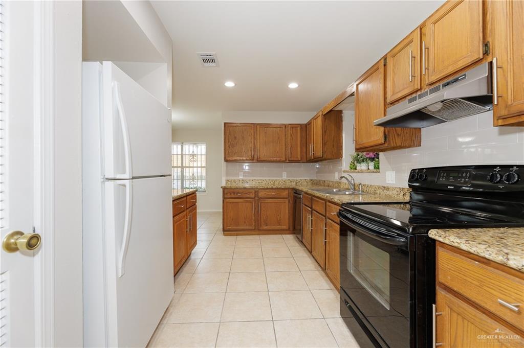 500 East El Rancho Avenue, Unit 26 McAllen, TX 78503 - Photo 17 of 27 a kitchen with stainless steel appliances granite countertop a refrigerator a sink and a stove