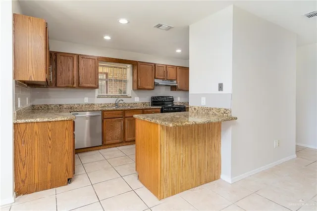 a kitchen with stainless steel appliances granite countertop a stove a sink and a refrigerator