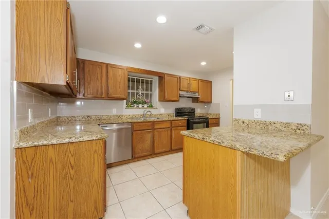 a kitchen with a sink a stove top oven and cabinetry